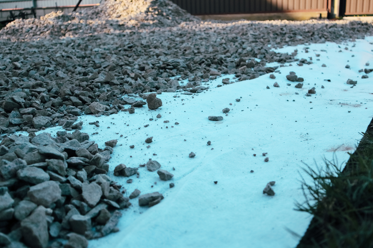 Pose d'un géotextile pour optimiser le drainage du sol.