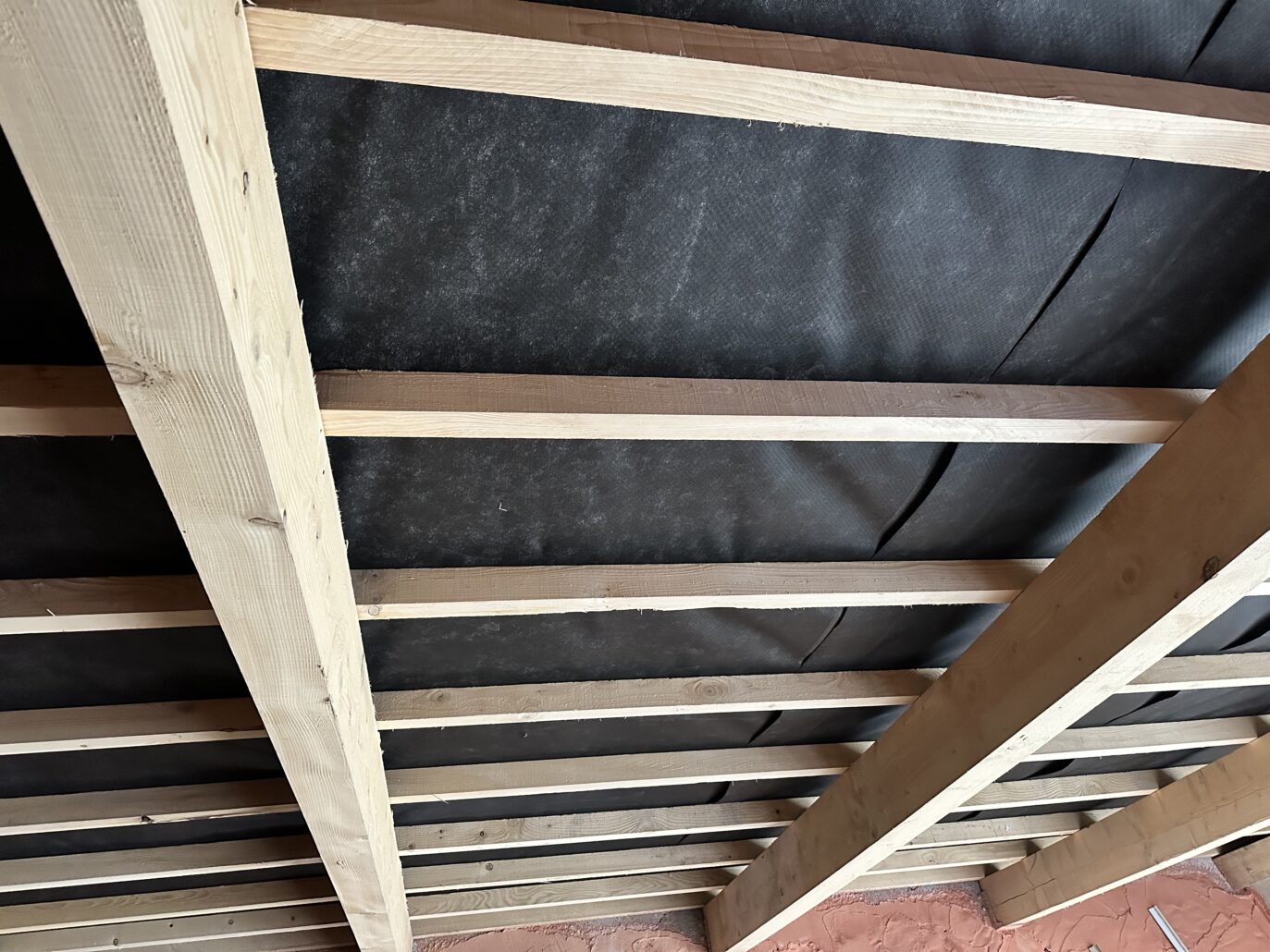 Pose d’une membrane HPV pour protéger une toiture des intempéries.